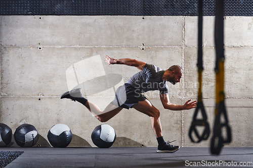 Image of A muscular man captured in air as he jumps in a modern gym, showcasing his athleticism, power, and determination through a highintensity fitness routine