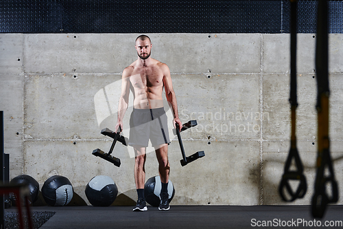 Image of A muscular man performs shoulder exercises in a modern gym, showcasing his strength and dedication to fitness.