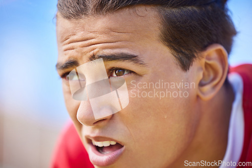 Image of Soccer player, tired and sweat on face after sports training, game or match feeling exhausted and breathing heavy outdoor after workout. Football, exercise and athlete man taking a break on pitch
