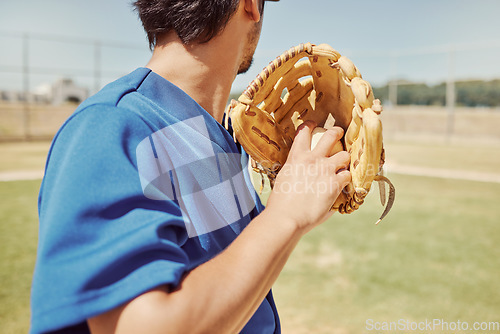 Image of Baseball, sports and man pitching during a game, training and professional event on a field. Back of athlete ready to throw a ball with a glove during an outdoor competition, fitness or cardio