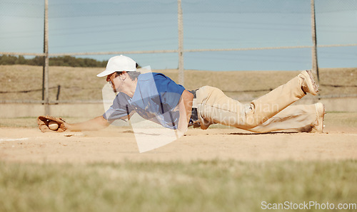 Image of Sports, action and a man catching baseball, sliding in dust on floor with ball in baseball glove. Slide, dive and catch, baseball player on the ground during game, professional athlete on the field.