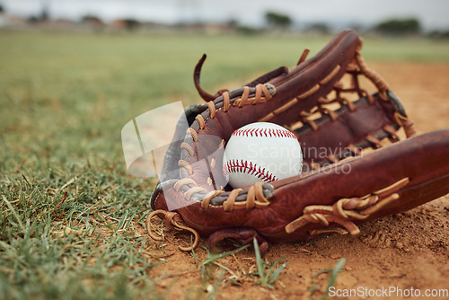 Image of Baseball, ball and glove on an outdoor pitch for sport training, fitness or a tournament game. Exercise, sports equipment and softball match on a professional field or stadium with grass and sand.