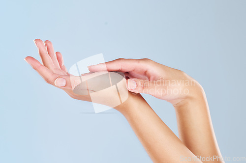 Image of Skincare, beauty and manicure with hands of woman and massage palm for wellness, health and spa against a blue background in studio. Salon, cosmetics and luxury with girl hand for clean dermatology