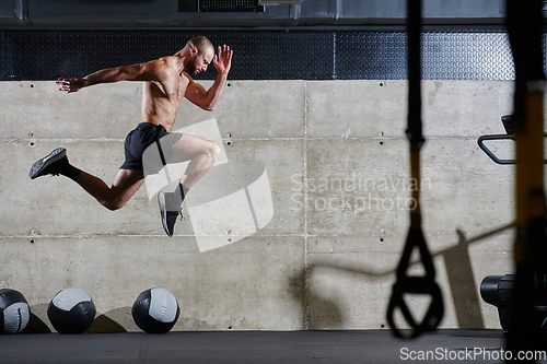 Image of A muscular man captured in air as he jumps in a modern gym, showcasing his athleticism, power, and determination through a highintensity fitness routine