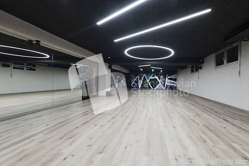 Image of An empty dance hall with a glass wall adorned with decorative graffiti, offering a fusion of contemporary, urban artistic ambiance and impressive aesthetics.