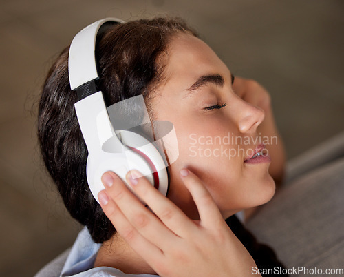 Image of Woman face, music headphones and peace on living room sofa, relax and freedom, calm lifestyle or mindfulness. Happy young girl listening to meditation audio, radio or sleeping sound in apartment home