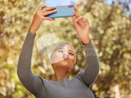 Image of Black woman, phone and selfie with pout in park with sunshine, summer and happiness by trees. Woman, smartphone and lips in kiss for photo, outdoor and nature with face in happy, funny and relax time