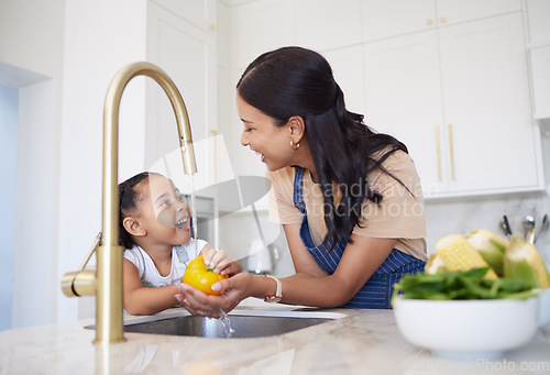 Image of Cooking, mother and child cleaning vegetables for dinner, lunch or diet in the kitchen of their house. Excited, happy and girl learning about food, nutrition and health from her mom for breakfast