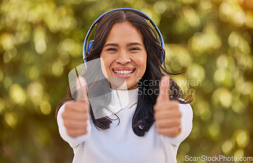 Image of Thumbs up, relax and woman in park with headphones on listening to music on weekend. Freedom, happiness and portrait of student on holiday, vacation and summer break in nature with wireless earphones