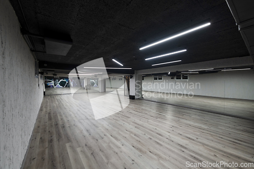 Image of An empty dance hall with a glass wall adorned with decorative graffiti, offering a fusion of contemporary, urban artistic ambiance and impressive aesthetics.