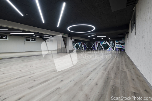 Image of An empty dance hall with a glass wall adorned with decorative graffiti, offering a fusion of contemporary, urban artistic ambiance and impressive aesthetics.