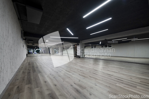 Image of An empty dance hall with a glass wall adorned with decorative graffiti, offering a fusion of contemporary, urban artistic ambiance and impressive aesthetics.