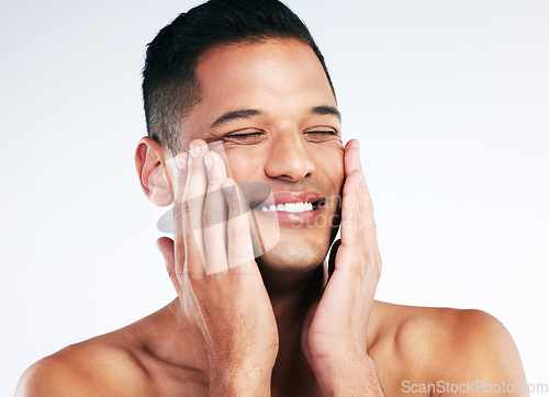 Image of Face, beauty and skincare with a man grooming in studio on a gray background for health or wellness. Happy, cosmetics and antiaging with a handsome young male touching is soft or smooth skin