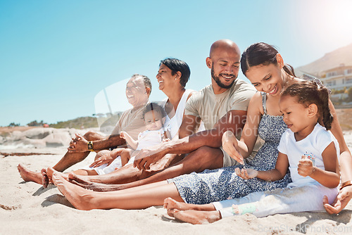 Image of Happy, family and relax with smile on beach for summer vacation and bonding time together in nature. Mother, father and grandparents with children relaxing on sandy shore smiling for holiday travel