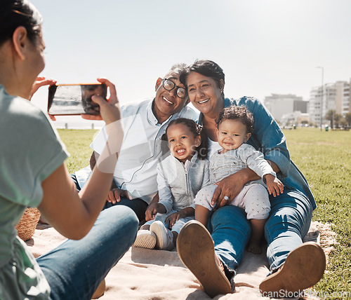 Image of Grandparents, children and mother with photo on a phone in park together during summer. Relax, happy and smile from kids and senior man and woman with picture on mobile from mom in nature by the sea