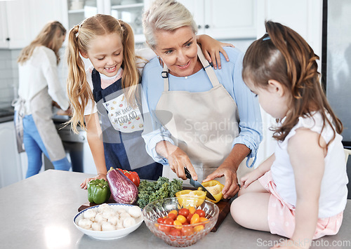 Image of Grandmother, children and cooking in the kitchen together with vegetables in the family home. Cutting, food and elderly woman in retirement teaching young girl kids to cook meal for lunch or dinner.