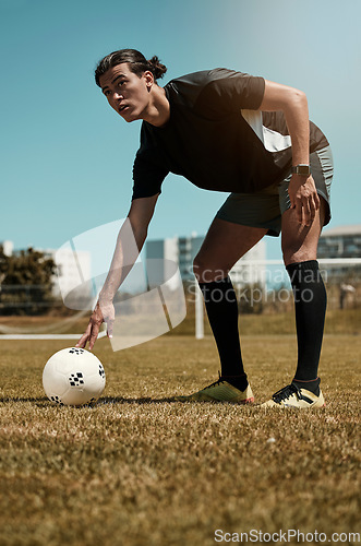 Image of Man, placing and soccer ball with hand on field for kick, penalty or goal in game, training or match. Sport, football and grass in summer for exercise, fitness and workout in sports for wellness