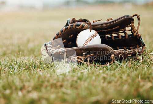 Image of Baseball, sport and ball with glove on a grass pitch or field outdoor for a competitive game or match. Fitness, sports gear and skill with equipment on the ground for training, practice and game