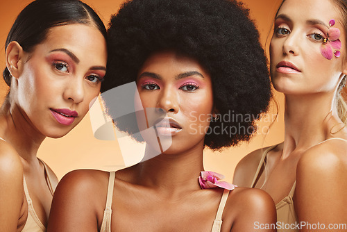 Image of Diversity, beauty and women with flowers for makeup, skincare and cosmetics. Skincare products, spa wellness and group of girls portrait in orange studio with pink orchids for natural beauty products