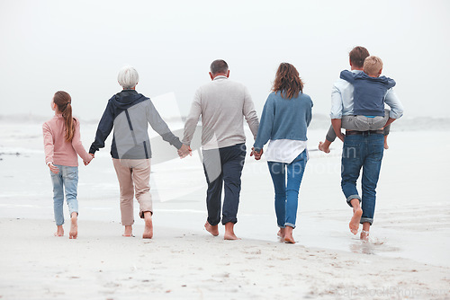 Image of Holding hands, walking and big family on the beach for exercise while on summer vacation. Grandparents, parents and children on outdoor walk in nature by ocean while on holiday, adventure or journey.