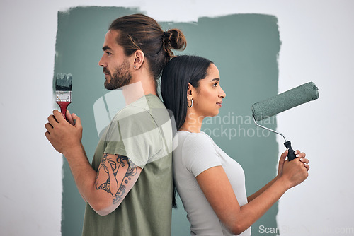 Image of Paint, renovate and diy with a couple in their home for painting, redecorating or improvement. House, interior and room with a man and woman painting a wall in their apartment for renovation