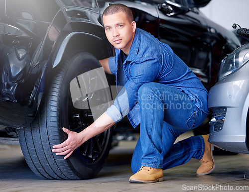 Image of Car, tire change and portrait of mechanic working on vehicle service, maintenance or test wheel for safety inspection check. Repair industry, automobile expert and man in garage workshop or auto shop
