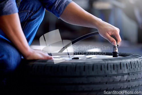 Image of Air pressure, tire and mechanic working in garage with pump in hand. Man in auto service, vehicle care and checking car wheel in workshop. Technician doing maintenance check in motor repair industry