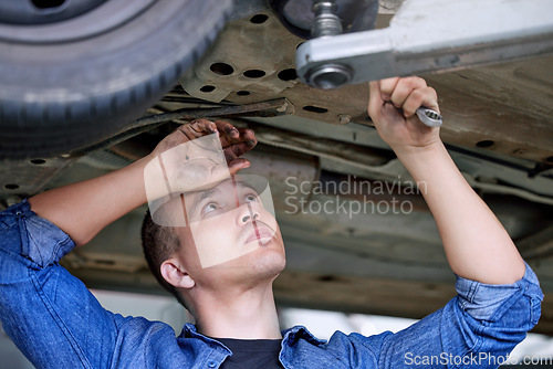 Image of Car service, repair and mechanic working on car in the garage or workshop. Motor care, engineer and repairman standing under vehicle with wrench doing inspection, maintenance and fixing automobile
