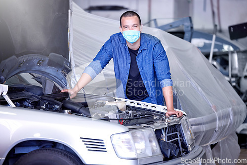 Image of Car, face mask and a mechanic in workshop during covid, safety, and insurance at work. Working, maintenance and quality assurance, man in a garage with vehicle and small business car mechanic startup