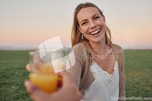 Image of Cheers, juice and portrait of a happy woman in nature on an outdoor picnic in a garden with a summer sunset. Happiness, smile and pov of a lady toasting with a orange drink while on a romantic date.