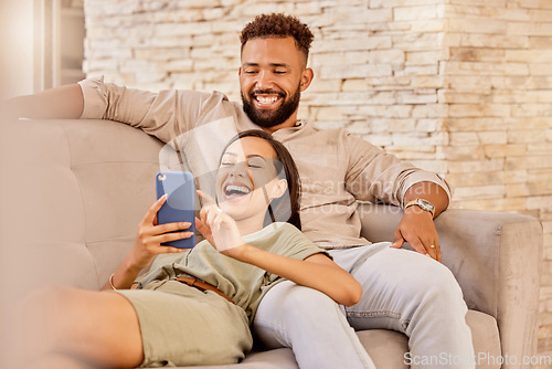 Image of Couple, laughing and phone funny meme content of happy people laughing on a lounge home couch. Mobile video streaming and social media app scroll of people with wifi technology on a house sofa