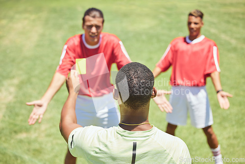 Image of Soccer, team and referee with yellow card, booking and foul a player on a grass pitch or field during a game. Fitness, football and discipline with a man ref giving a caution during a sports match