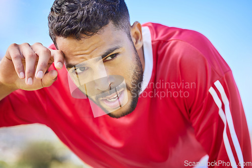 Image of Soccer, sports and tired young athlete at a game, training or workout on an outdoor field. Fitness, exercise and healthy man player taking breathe while playing football match on pitch at the stadium