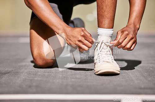 Image of Man, shoes and laces getting ready for basketball match, game or competition while outdoor in summer. Basketball player, sports and sneakers for running on basketball court before contest in sunshine