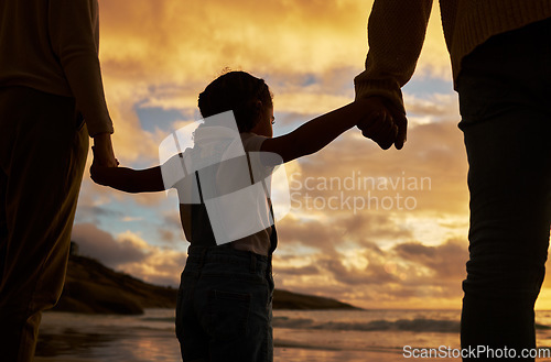 Image of Parents, child and silhouette of holding hands on the beach during sunset for family bonding in the outdoors. Kid hand, mother and father enjoying the scenic view, care and freedom on the ocean coast