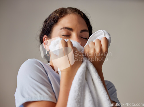Image of Woman smelling a clean towel after doing laundry at her home, hotel or resort while spring cleaning. Housekeeping, maid or housewife doing washing for maintenance, hygiene and fresh fabrics or cloth.