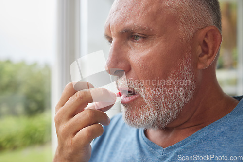 Image of Retirement man and depression pills in hand for mental health with pensive stare at window. Thinking face of senior male with medicine for self care and wellbeing in Canada nursing home.