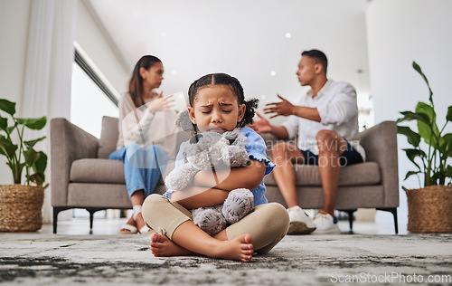 Image of Parents, fighting and sad girl in living room with teddy bear for support or comfort. Family, divorce and husband in argument with wife and scared kid sitting in fear, stress or depression on carpet