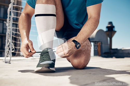 Image of Soccer, man and tie shoe for training, exercise and workout on concrete court before sports game and match. Football, fitness and athlete prepare shoes for cardio sport performance on outdoor court