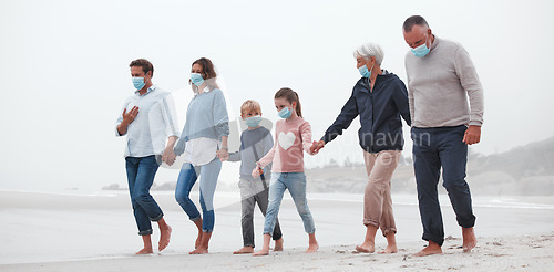 Image of Big family, covid and holding hands walking on beach for quality bonding time together during pandemic in nature. Hand of parents, grandparents and kids in travel, freedom and family walk with masks