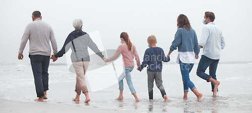 Image of Big family, holding hands and walking on beach for vacation or quality bonding time together in nature. Hand of parents, grandparents and kids enjoying travel, freedom and family fun in ocean water