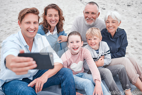 Image of Family, generations and selfie, together and happy on outdoor adventure at beach, smartphone and technology. Parents, grandparents and children smile, spending quality time and bonding at the coast.