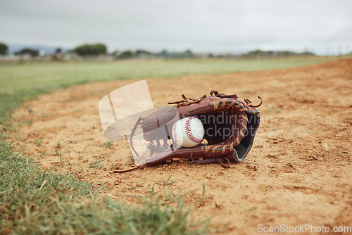 Image of Sports, baseball gloves and field ball on dirt floor after game, competition or practice match for fitness, exercise or health. Softball pitch, training ground or baseball field equipment for workout