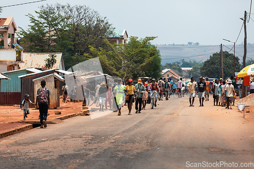 Image of Candid street photography of local residents walking and going about their daily lives on Mandoto street in Madagascar.
