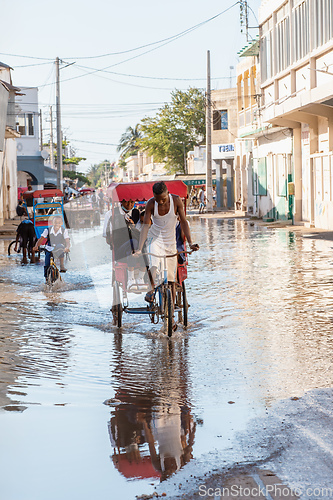 Image of Traditional rickshaw bicycle with Malagasy people on the street of Toliara, one of the ways to earn money. Everyday life on the street of Madagascar.