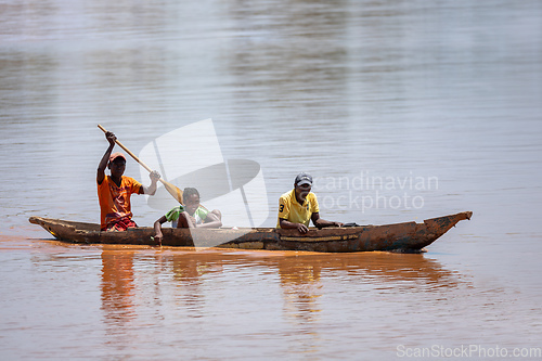 Image of Malagasy family in traditional wooden boat ride on the Mania River in Madagascar.
