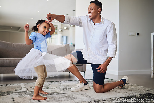 Image of Black father, girl and being happy, dance and have fun together in living room. Dad, young female child and daughter doing quality time, dancing and in tutu dress for play, celebration and happiness.