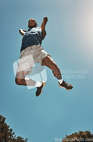 Image of Sports, blue sky and basketball man jump for game, competition or slam dunk training, practice or workout. High energy, athlete motivation and basketball player doing fitness or exercise bottom view