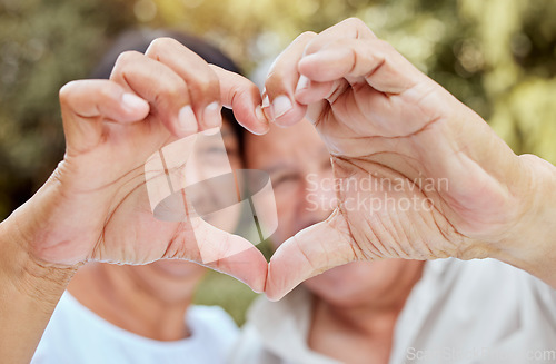 Image of Heart hands, love and senior couple, happiness and kindness, trust and support in garden park. Closeup marriage, finger shape and celebrate care relationship, anniversary date and relax retirement