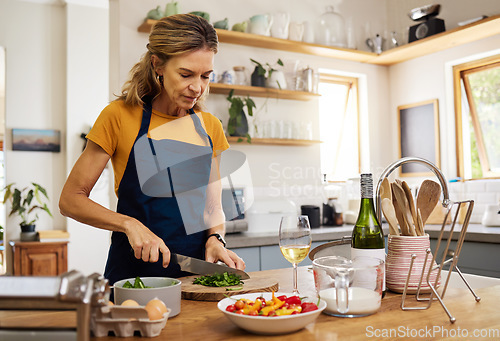 Image of Mature woman, cooking and cutting salad leaf in house and home kitchen for wellness food, health diet and lunch meal. Chef, nutritionist and person with cuisine knife for vegetables or dinner recipe